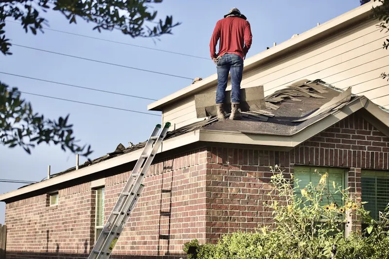 Professional roofer working on a residential roof in Etna